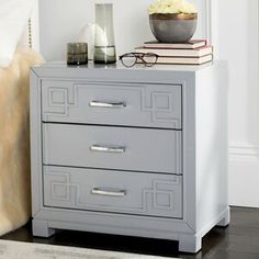 a nightstand with two drawers and a vase on top