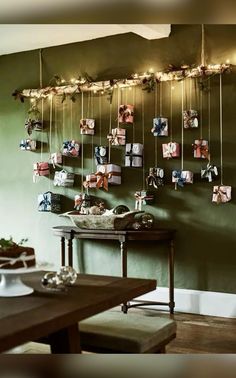 a dining room with green walls and pictures hanging on the wall, along with a wooden table