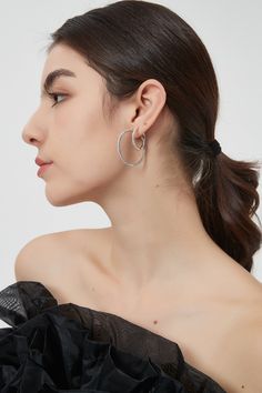 The slender silver hoops embrace a contemporary and refined aesthetic, embracing simplicity as the ultimate form of glamour. They are a testament to the timeless elegance that comes from the harmonious blend of cold silver and the scintillating brilliance of cubic zircons. Crafted with precision and finesse, the delicate hoops exude a captivating aura that gracefully adorns your ears. The lustrous silver hoops provide a classic backdrop for the star of the show and give an irresistible sparkle t Modern Silver Hoop Earrings For Party, Modern Silver Hoop Earrings For Formal Occasions, Modern White Gold Single Hoop Earring, Modern Silver Wrap Earrings For Everyday, Modern Silver Single Wrap Earring, Minimalist Sterling Silver Hoop Earrings For Party, Metal Open Circle Hoop Earrings, Modern Silver Hoop Earrings, Silver Hoop Earrings With A Modern Twist