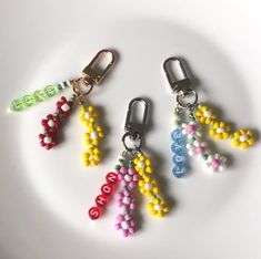 four beaded key chains on a white plate