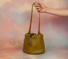 We know you. You want to carry a cute, mini bag, but you also want to fit everything in it. We can relate! Stop leaving your things at home, and start carrying the Duo bag. Not only is it large enough to fit your wallet, phone, sunglasses, and lots of accessories, this leather bucket bag has a drawstring and clasped strap so you can wear it lots of ways. In fact, that’s why we call it Duo! Our two strap settings allow for you to wear it shorter as a chic wristlet or wear it as a slouchy shoulder Versatile Faux Leather Bucket Bag For On-the-go, Gold Leather Bucket Bag With Gold-tone Hardware, Brown Bucket Bag With Gold-tone Hardware For On-the-go, Versatile Brown Bucket Bag With Gold-tone Hardware, Leather Mini Bag, Cognac Bucket Bag With Adjustable Strap, Pouch Shape, Drawstring Bucket Bag, 3rd Anniversary Gifts, The Duo