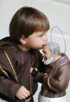 a little boy that is standing next to a figurine in front of him