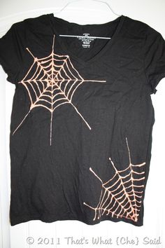 a black t - shirt with spider webs on it