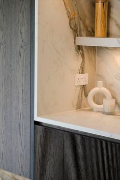 a bathroom with marble walls and white fixtures