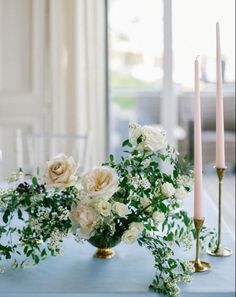 flowers and candles on a blue table cloth