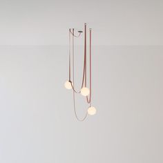 three light fixtures hanging from the ceiling in a room with white walls and flooring