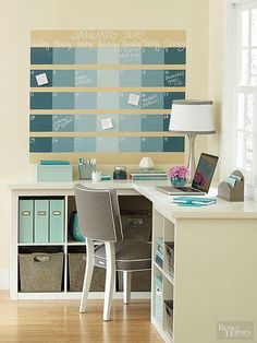 a desk with two chairs and a large calendar on the wall in front of it