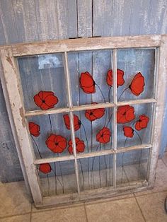 an old window with red flowers painted on it