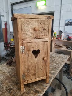 a wooden cabinet sitting on top of a table in a room filled with woodworking tools