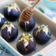 some food is in a blue dish with a wooden utensil sticking out of it