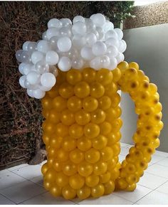 a beer mug filled with white and yellow balloons