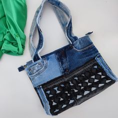 an old pair of jeans has been transformed into a handbag with crochet detailing