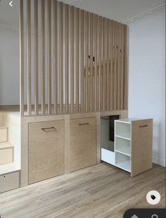 an empty room with some cabinets and drawers on the floor, next to a stair case that is made out of plywood