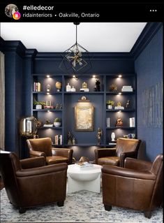 a living room with blue walls and leather chairs