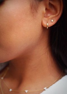 a close up of a woman's ear with two small stars on the side