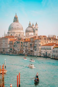 boats are traveling on the water in front of buildings and domed domes, venice italy