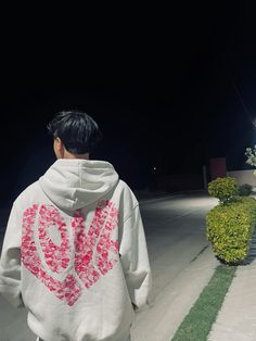 a man wearing a hoodie with the word love written on it in pink letters