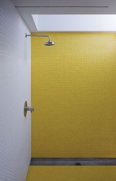 a yellow tiled shower stall in a bathroom