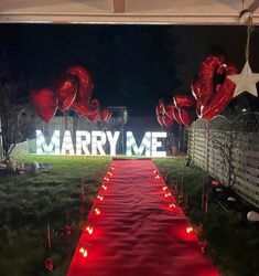 a red carpeted path leading to a large sign that says marry me