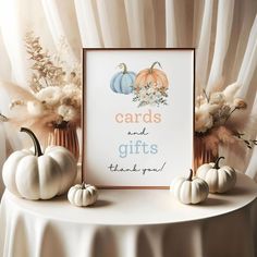 there are three pumpkins sitting on the table next to a card and gifts sign