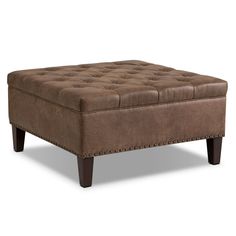 a brown ottoman sitting on top of a wooden table