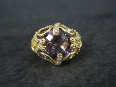 This stunning estate ring is gold vermeil over sterling silver. It features a faceted amethyst accented by genuine diamonds. The face of this ring measures 5/8 of an inch north to south with a rise of 9mm off the finger. Size: 8 The designers hallmark is JH but I cannot seem to identify who that is. Condition: Flawless Elegant Luxury Faceted Amethyst Ring, Luxury Faceted Amethyst Fine Jewelry Ring, Luxury Antique Amethyst Ring, Luxury Vintage Amethyst Ring With Polished Finish, Gold Amethyst Ring, Fine Jewelry Collectible, Estate Rings, Amethyst And Diamond Ring, Multi Stone Ring, Gold Vermeil