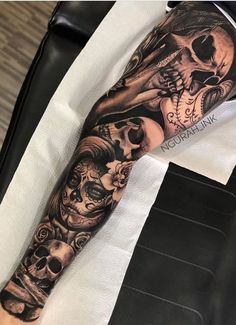 a man's arm with tattoos on it and two skulls in the middle of his arm