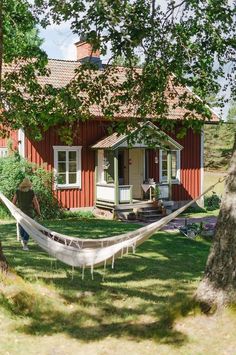 a hammock in front of a red house