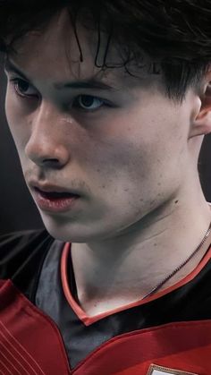 a close up of a young man wearing a uniform and looking at the camera with an intense look on his face