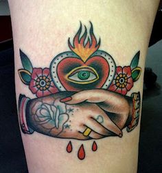 a close up of a person's arm with tattoos on it and an eye in the background