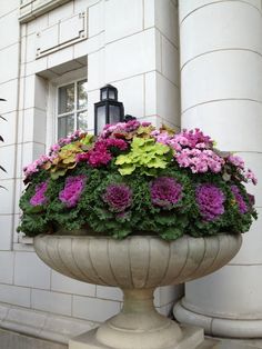 a planter filled with lots of flowers next to a building