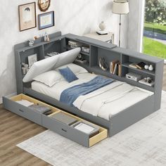 a bed with drawers underneath it in a room