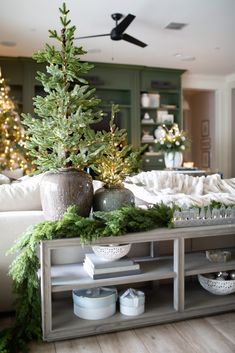 a living room filled with furniture and christmas trees in vases on top of a table