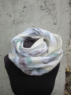 This beautiful merino wool snood scarf is Nuno felted onto fine quality cotton voile. Made in a loop it can be worn like it is around your neck or wrapped around twice for a more sung fit. It is light and warm , made from all natural fibres , finest quality merino wool with silks and linen fibres. I can make this piece in any colour to match any outfit , so do get in touch and message me. This piece will be custom made for you . it must be remembered that each garment is individually unique and White Bohemian Scarf For Fall, White Bohemian Winter Shawl, White Bohemian Scarf One Size, White Winter Shawl As Gift, White Winter Shawl Gift, White Winter Shawl Perfect As A Gift, Bohemian Cream Scarves For Winter, White Artistic Handmade Scarves, Artistic Handmade White Scarves