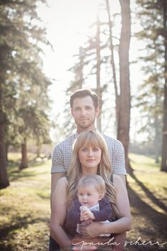 a man and woman holding a baby in their arms