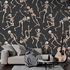 a living room with a couch, guitar and skeleton wallpaper