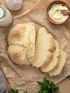 a loaf of bread sitting on top of a piece of paper next to a bowl of butter