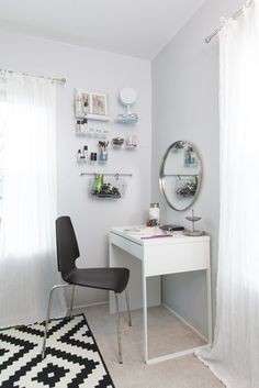 a white desk and chair in a room with a black and white rug on the floor