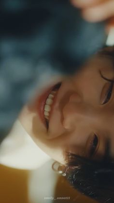 a close up of a woman smiling with her eyes closed