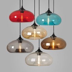 five different colored glass pendant lights hanging from the ceiling