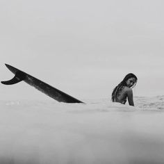 a woman in the water with a surfboard