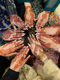 many hands are arranged in a circle with henna designs on their palms and fingers