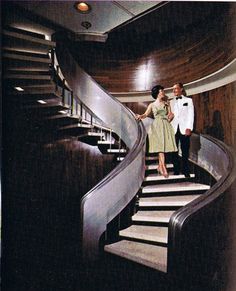 a man and woman standing on top of a set of stairs next to each other