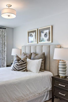 a white bed sitting in a bedroom next to two framed pictures