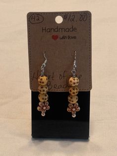 Natural painted wood trible beads. Tan color with darker tan stars, cream color with brown tone flower markings. Small spacers and made with stainless steel eye pins and sterling silver ear wires Adjustable Brown Earrings With Wooden Beads, Artisan Brown Beaded Nickel-free Earrings, Adjustable Brown Beaded Earrings With Large Beads, Brown Dangle Earrings With Large Beads, Brown Wooden Beaded Earrings As Gift, Brown Wooden Beads Beaded Earrings As A Gift, Brown Beaded Earrings With Wooden Beads For Gift, Gift Brown Beaded Earrings With Wooden Beads, Artisan Brown Earrings With Wooden Beads