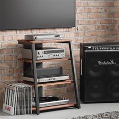 an entertainment center in front of a brick wall with speakers and music equipment on it