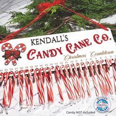 candy canes are hanging from a sign for kendal's candy cane co