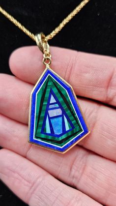 14k Intarsia set in Lapis with an enhancer bail to fit larger chains or beads. Beautiful stone inlay pendant. Intarsia is an incredible artform and this is a fantastic example. The lapis is inlayed with geometric pieces of opal, malachite, turquois, and onyx. It is bezel set in 14k with an open back exposing the lapis base. No two are alike so each one is unique. Literally wearable art. I love wearing this one on an omega, a strand of turquois beads, or a thicker gold chain.  Enhancer bail stamp Art Deco 14k Gold Pendant Jewelry, Modernist Turquoise Jewelry Gift, Sterling Silver Jewelry With Green Inlay, Art Deco Pendant Jewelry With Polished Finish, Modernist Blue Gemstone Jewelry, Collectible 14k Gold Green Jewelry, Art Deco Polished Pendant Jewelry, Elegant Green Jewelry With Inlay, Elegant 14k Gold Jewelry With Inlay