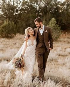 a bride and groom walking through tall grass