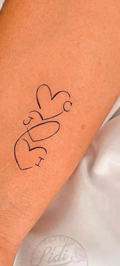 a woman's arm with a tattoo on it that says love and two hearts